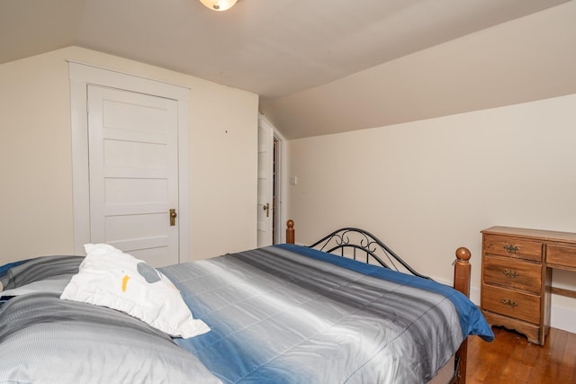 bedroom with lofted ceiling and wood finished floors