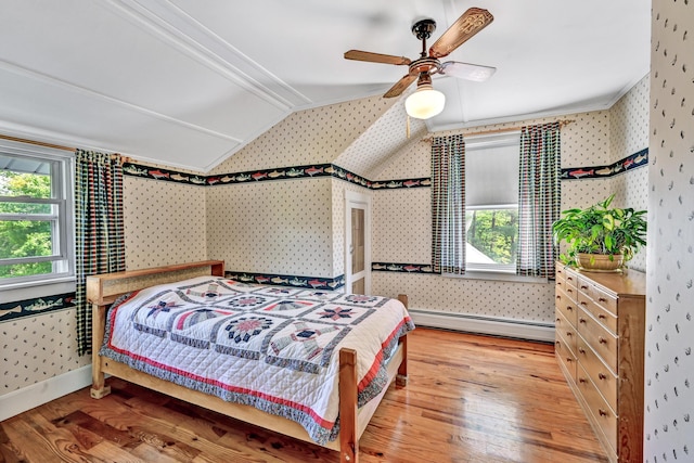 701 Augusta Rd, Winslow, ME 04901 - bedroom featuring vaulted ceiling, a baseboard radiator, wallpapered walls, and wood finished floors