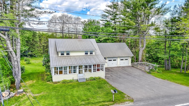 701 Augusta Rd, Winslow, ME 04901 - view of front of house with a garage, metal roof, entry steps, a front lawn, and a chimney