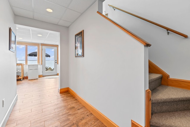 21 White Rd, Georgetown, ME 04548 - corridor with baseboards, a drop ceiling, stairway, and light wood-style floors