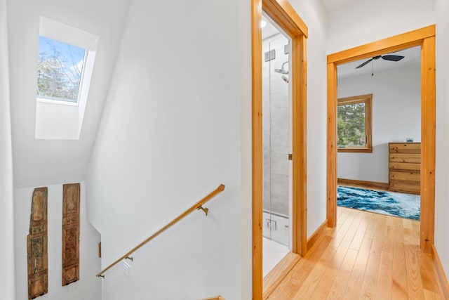 21 White Rd, Georgetown, ME 04548 - hall with light wood finished floors, a skylight, baseboards, and an upstairs landing