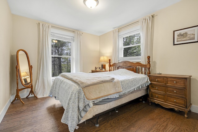 bedroom with dark wood-style floors and baseboards