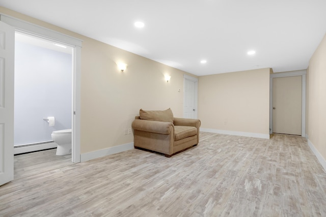 sitting room featuring baseboard heating, light wood-style flooring, baseboards, and recessed lighting