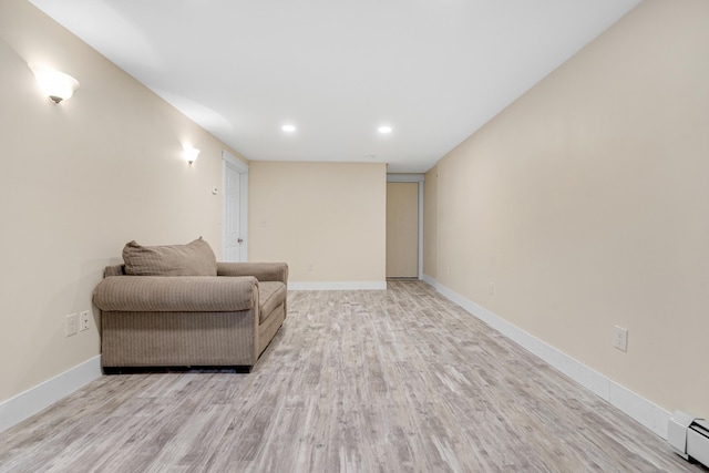 sitting room featuring a baseboard radiator, wood finished floors, baseboards, and recessed lighting