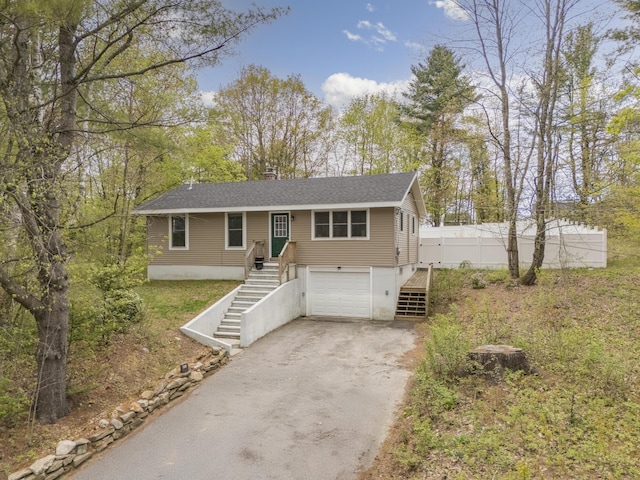view of front facade featuring stairs, asphalt driveway, a garage, and a shingled roof