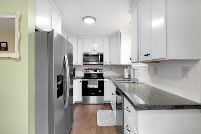 kitchen featuring stainless steel appliances, a sink, white cabinetry, and dark wood finished floors