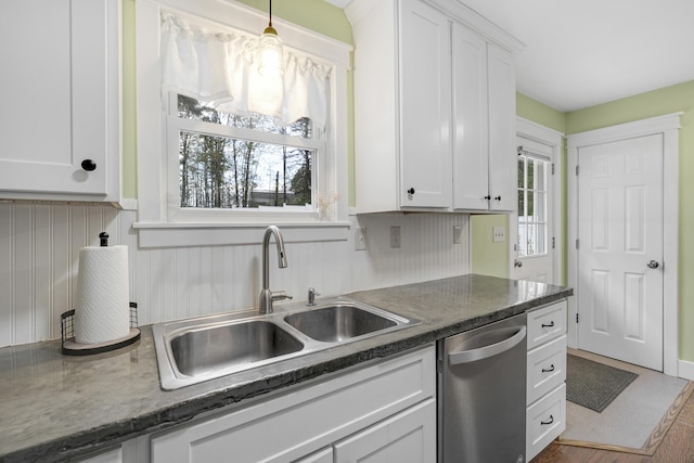 kitchen with dishwasher, a sink, white cabinets, and hanging light fixtures