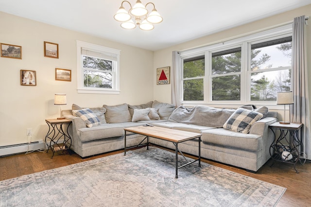 living area with healthy amount of natural light, a chandelier, wood finished floors, and a baseboard radiator