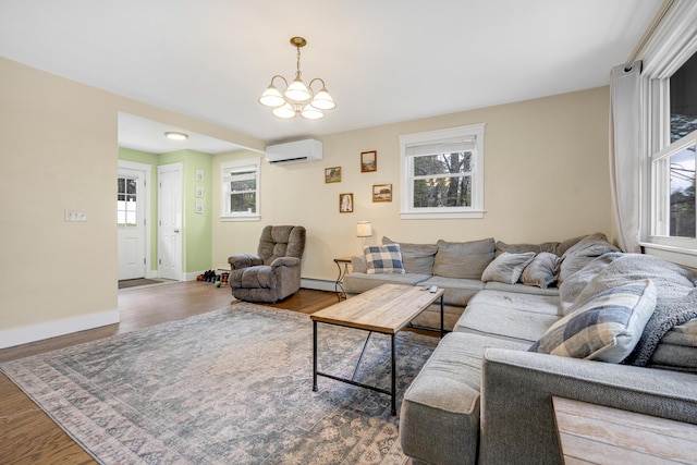 living area featuring an AC wall unit, a baseboard radiator, wood finished floors, and a chandelier