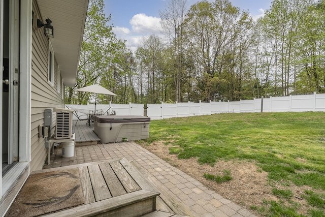 view of yard featuring a hot tub, a deck, and view of wooded area