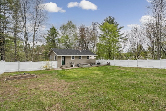 rear view of property with a vegetable garden, view of scattered trees, a chimney, and a jacuzzi