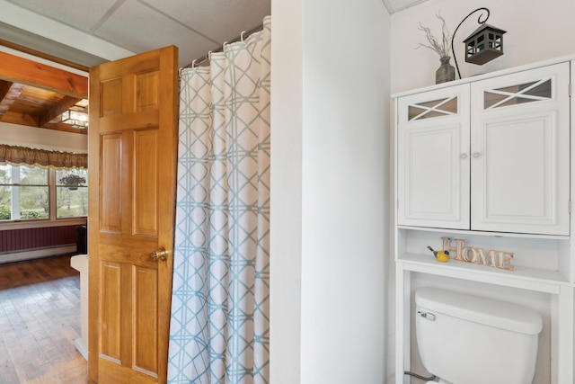 full bathroom featuring a baseboard radiator, wood finished floors, toilet, and a shower with curtain
