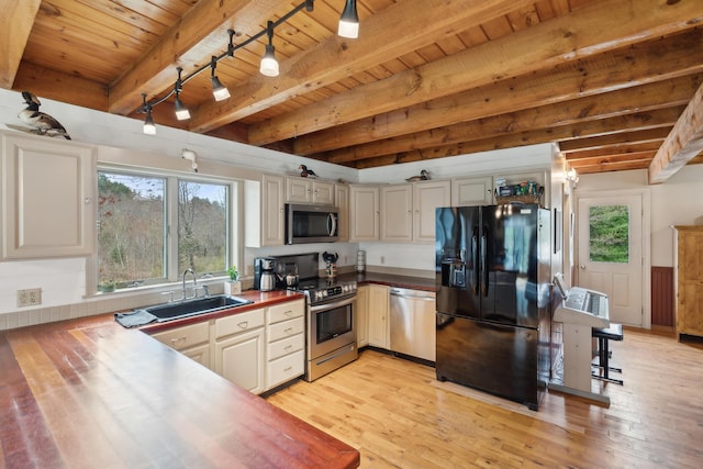 kitchen featuring stainless steel appliances, a sink, wooden ceiling, light wood-style flooring, and plenty of natural light