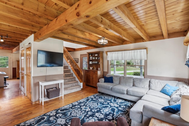 living area with wooden ceiling, beam ceiling, wood finished floors, a wainscoted wall, and stairway