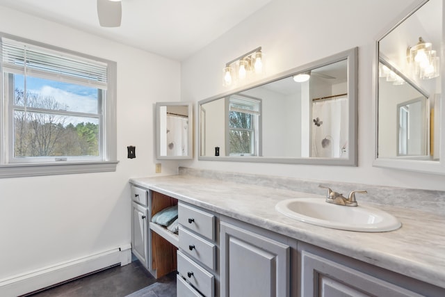 full bathroom with baseboard heating, vanity, healthy amount of natural light, and ceiling fan