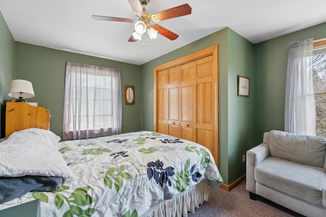 carpeted bedroom featuring multiple windows, a closet, a ceiling fan, and baseboards