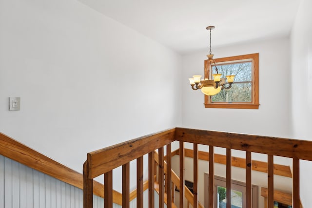 stairs with a chandelier