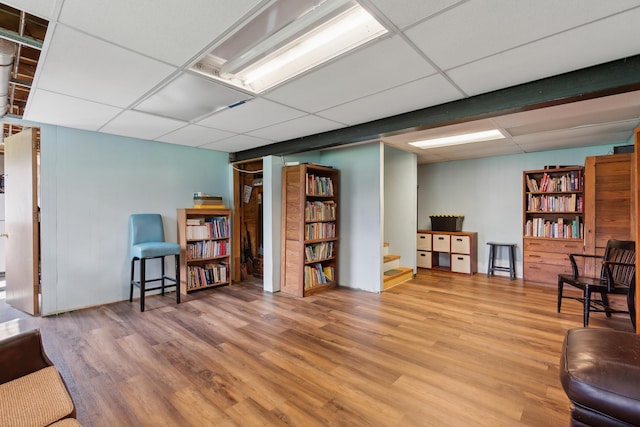 sitting room with a paneled ceiling and wood finished floors