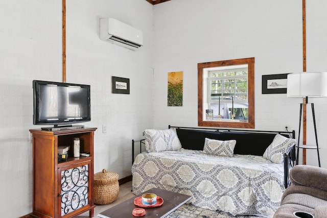 bedroom with a wall mounted air conditioner and a towering ceiling