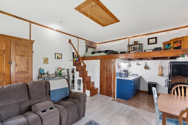 living area with light wood finished floors and stairs