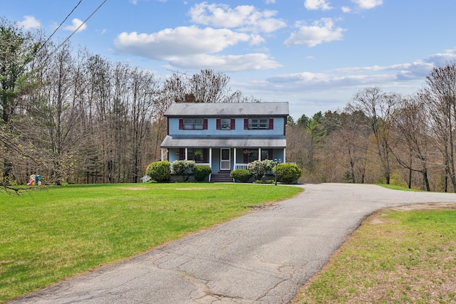traditional-style house with covered porch, a front lawn, and driveway