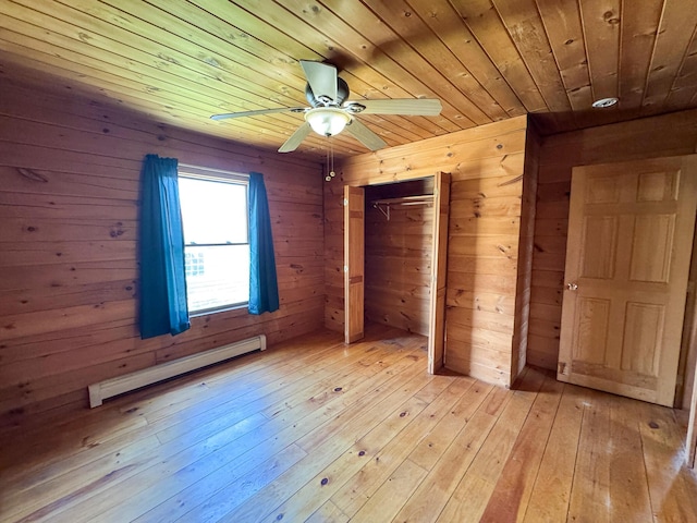 111 Fryes Ln, Greenbush, ME 04418 - unfurnished bedroom with baseboard heating, wood ceiling, light wood-type flooring, wood walls, and a closet