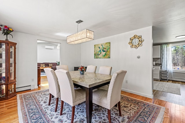 48 Albion Rd, Windham, ME 04062 - dining area featuring light wood-style flooring, a wall unit AC, a baseboard radiator, and baseboards