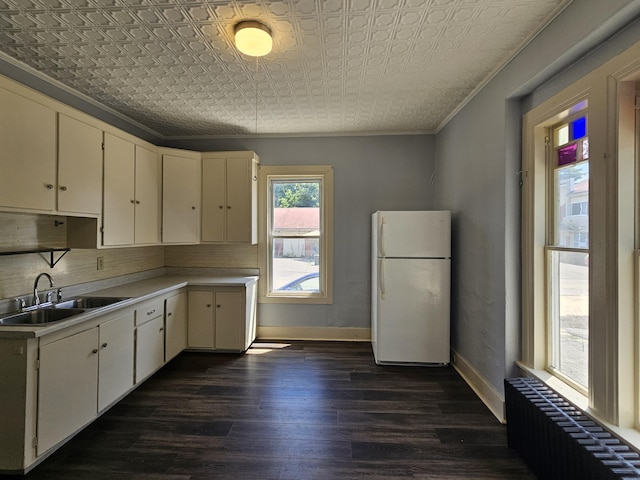 kitchen with freestanding refrigerator, an ornate ceiling, a sink, radiator heating unit, and light countertops