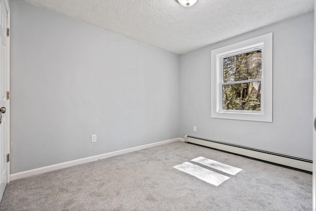 carpeted spare room featuring a baseboard heating unit, a textured ceiling, and baseboards