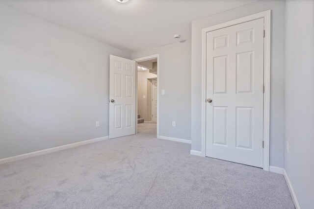 unfurnished bedroom with carpet flooring and baseboards