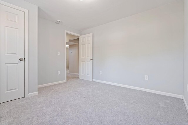 unfurnished bedroom featuring carpet flooring and baseboards