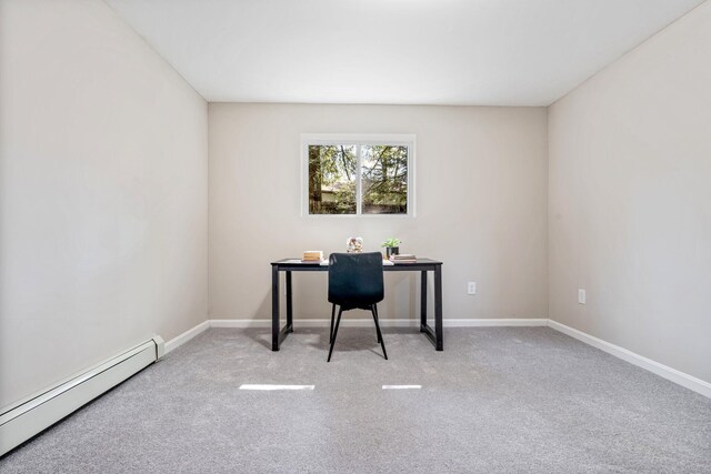 unfurnished office with a baseboard heating unit, carpet, and baseboards