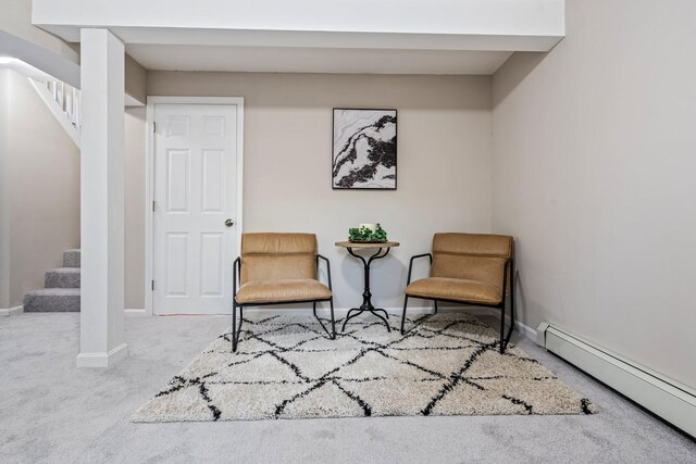 sitting room with baseboard heating, carpet flooring, stairway, and baseboards