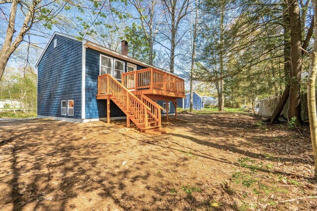 rear view of house featuring stairway, a chimney, and a deck