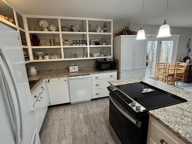 kitchen featuring open shelves, white cabinetry, light wood-type flooring, light stone countertops, and white appliances