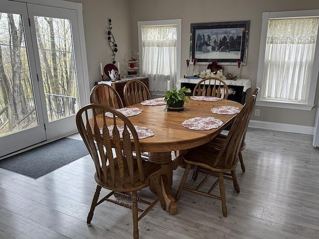dining area featuring baseboards, plenty of natural light, and light wood-style floors