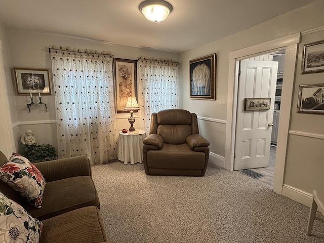 living area with a wealth of natural light, visible vents, and carpet floors