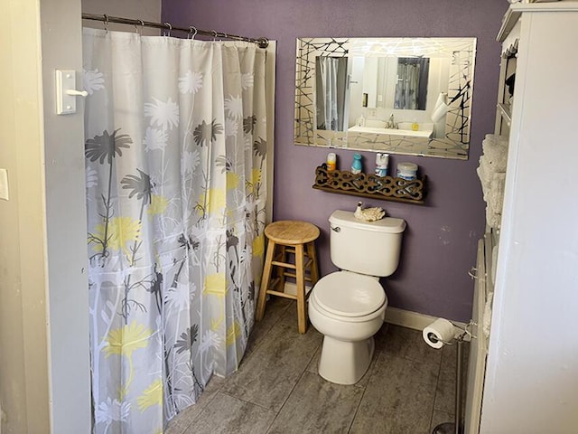 bathroom with tile patterned flooring, toilet, a shower with shower curtain, and baseboards