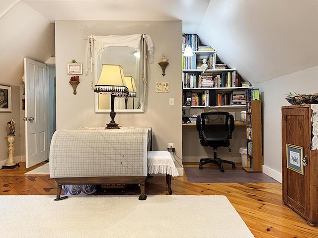 office featuring vaulted ceiling, baseboards, and wood finished floors