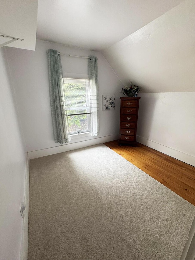 bonus room featuring light wood finished floors, lofted ceiling, and baseboards