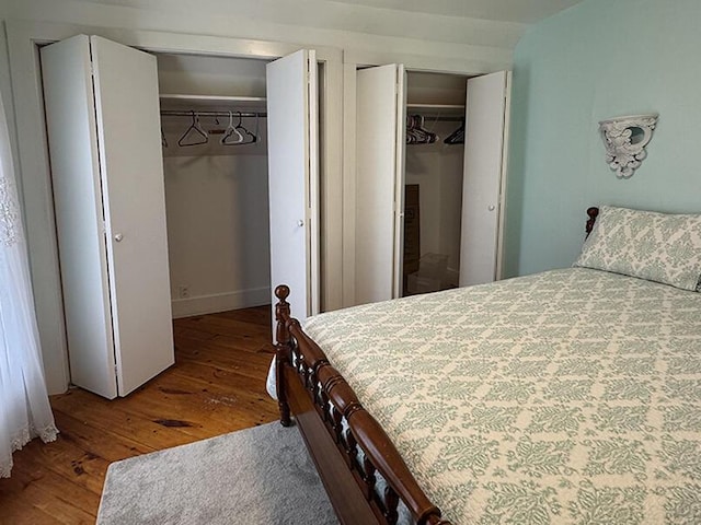 bedroom featuring multiple closets and hardwood / wood-style flooring