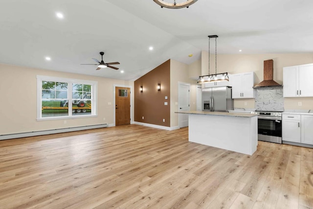 26 June St, Sanford, ME 04073 - kitchen with wall chimney exhaust hood, appliances with stainless steel finishes, a center island, baseboard heating, and white cabinetry