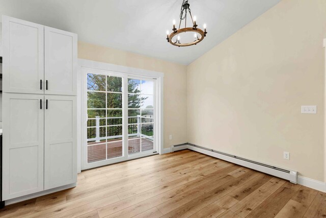 26 June St, Sanford, ME 04073 - entryway with a chandelier, baseboard heating, light wood-style flooring, vaulted ceiling, and baseboards