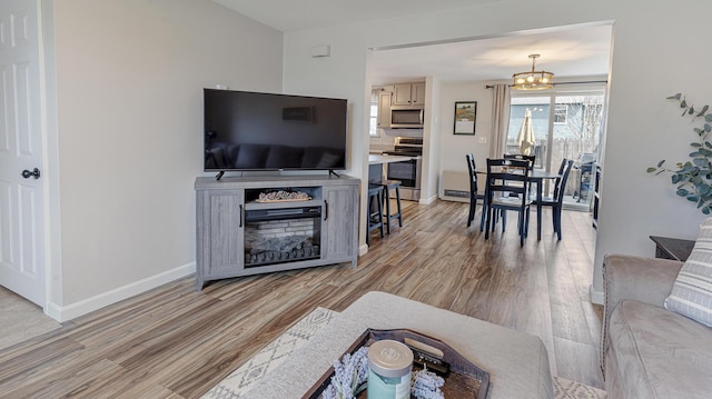 8 Orchard Hills Pkwy Unit 8, Bangor, ME 04401 - living room featuring light wood-style flooring, a chandelier, baseboards, and a fireplace