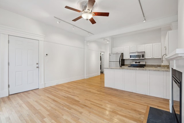 17 Pine St Unit 1, Portland, ME 04102 - kitchen with track lighting, appliances with stainless steel finishes, a peninsula, and white cabinetry