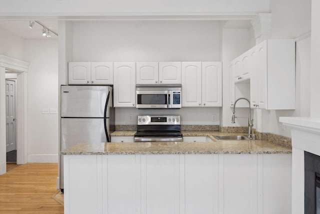 17 Pine St Unit 1, Portland, ME 04102 - kitchen featuring stainless steel appliances, a sink, a peninsula, and light stone counters