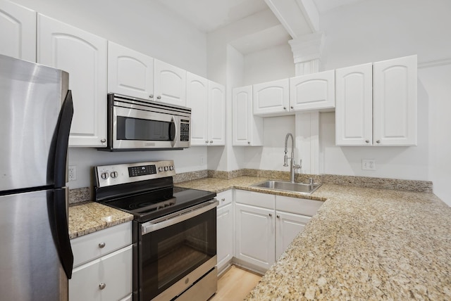 17 Pine St Unit 1, Portland, ME 04102 - kitchen with stainless steel appliances, a sink, white cabinetry, and light stone countertops