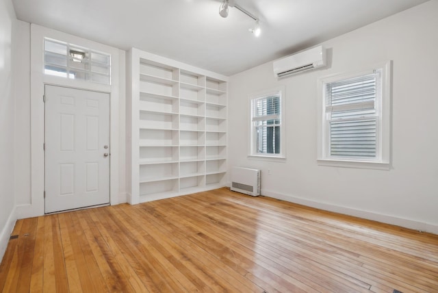 17 Pine St Unit 1, Portland, ME 04102 - unfurnished room with light wood-style flooring, built in features, an AC wall unit, and baseboards