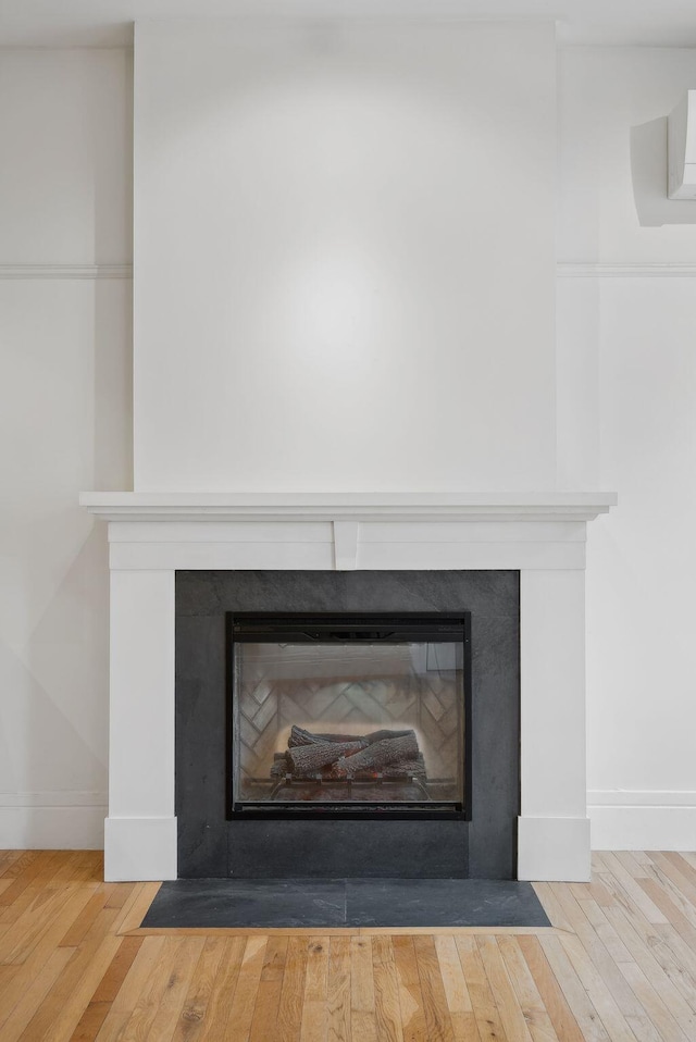 17 Pine St Unit 1, Portland, ME 04102 - detailed view of a fireplace with flush hearth, baseboards, and wood finished floors