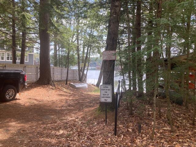 exterior space featuring a water view and fence